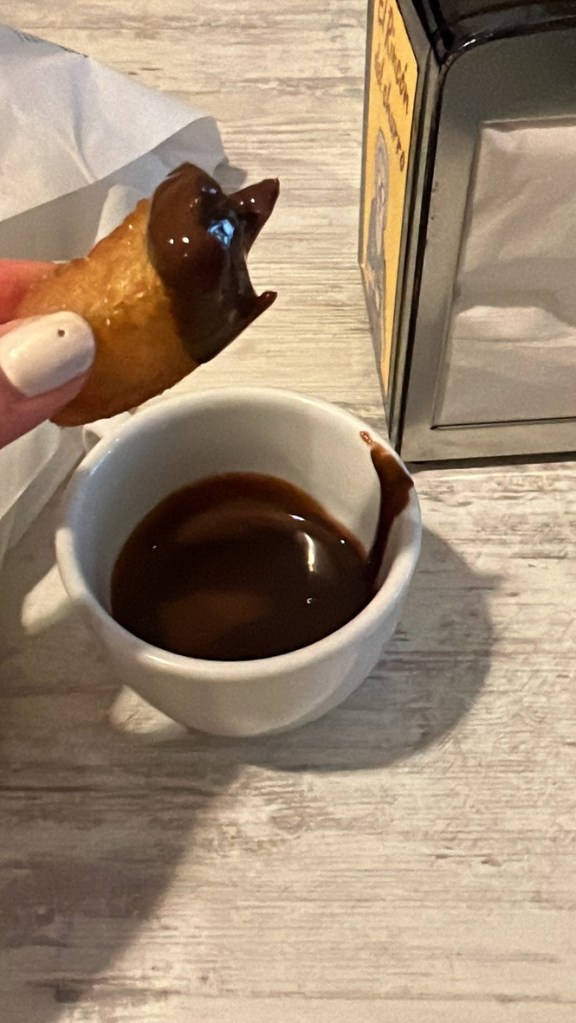 Churro dipped into a dish of chocolate